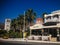 Elounda, Crete, Greece - September 2: Greek street overlooking a cafe and church. Tall palm trees on a background of mountains