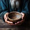 Emaciated hands hold an empty bowl against wood, depicting the reality of hunger