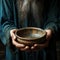 Emaciated hands hold an empty bowl against wood, depicting the reality of hunger