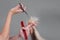 Emale hairdresser hold in hand between fingers lock of blonde hair, comb and scissors closeup. Image of hairdresser trimming ends