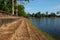 Embankment of the ancient royal pond in Cambodia. Medieval stone buildings on the shore