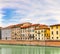 Embankment of The River Arno in The Italian City of Pisa. A bridge passes over the river and houses on both sides are overlooking