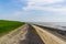 The embankment with walking path at the beach of Tholen, Bergse diepsluis, Oosterschelde, Zeeland, The Netherlands