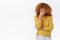 Embarrassed attractive modern redhead curly girlfriend in yellow sweater blushing as boyfriend behaving dumb in front of