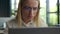 Embarrassed Caucasian woman businesswoman girl in eyeglasses looking at laptop computer overwork female office worker