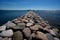 Embedded stones. Rocky beach, peaceful sea, harbor. Mole in Munalaid