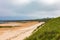 Embleton Bay and Burn sandy beach with the ruins of Dunstanburgh Castle