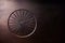 Embossed or carved vintage wheel of a cartwheel or a carriage in wooden surface background