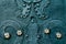 Embossed metallic green-blue background with baroque details and with buttons metal gold flowers
