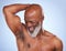 Embrace your natural self. Studio shot of a mature man drying his armpit after applying deodorant against a blue