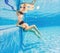 Embracing aquatic fitness, a pregnant woman demonstrates strength and serenity in underwater aerobics, creating a serene