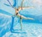 Embracing aquatic fitness, a pregnant woman demonstrates strength and serenity in underwater aerobics, creating a serene