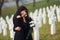 Embracing each other and crying. Two young women in black clothes visiting cemetery with many white crosses. Conception of funeral