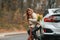 Embracing each other. Holding fallen leaves. Mother with her daughter is outdoors near electric car outdoors