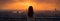 Embracing solitude: A woman gazes at the sunset behind the busy skyscrapers