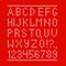 Embroided by cross stitch english alphabet with numbers and symbols on red cloth texture.