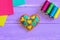 Embroidered heart ornament. Valentines Day heart ornament, thread set, colorful felt sheets on a wooden table. Embroidery motif