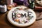 The embroidered word Home on an embroidery hoop. Created with Generative AI