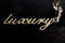 embroidery of gold lettering & x22;luxury& x22; on black velvety fabric