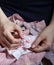 Embroidery in woman hands, female doing flower pattern embroidery on children natural clothes