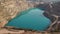 Emerald Azure lake in a flooded quarry in the shape of a heart. Oval lake in mining industrial crater, acid mine