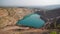 Emerald Azure lake in a flooded quarry in the shape of a heart. Oval lake in mining industrial crater, acid mine