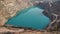 Emerald Azure lake in a flooded quarry in the shape of a heart. Oval lake in mining industrial crater, acid mine