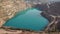 Emerald Azure lake in a flooded quarry in the shape of a heart. Oval lake in mining industrial crater, acid mine