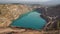 Emerald Azure lake in a flooded quarry in the shape of a heart. Oval lake in mining industrial crater, acid mine