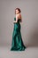 Emerald ball gown. Young lady in long green evening dress. Ginger woman posing in studio