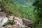 Emerald green infinity pool overlooking dense jungle and waterfall