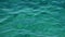 Emerald green sea ripples running on water surface