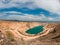 Emerald lake in a flooded quarry. Emerald green lake in flooded opencast mine, open pit. Oval lake in mining industrial crater,