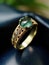 Emerald and platinum gold ring with cross-cut detail in dark aquamarine and gold