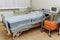 Emergency area in the clinic. Light sterile recovery room with bed. The light is on. Ambulance box. Medical equipment. Trolley for