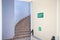 Emergency exit door with exit sign. Exit up the stairs. Fire escape in a modern building.