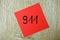 Emergency number 911 written on a red sticker