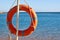 Emergency orange life buoy on sea beach