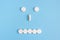 Emoticon from medical pills on a blue background. The concept of healthcare