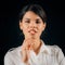 Emotion Curiosity. Portrait of a beautiful curious young woman holding finger up, expressing curiosity, studio portrait, black