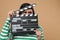 Emotional actress with clapperboard on beige background. Film industry