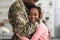 Emotional african american girl hugging her father in military uniform