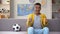 Emotional African-American teenager watching football match on TV, national team