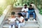 Emotional african students looking excited in laptop, sitting outside on campus stairs, education