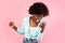 Emotional Black Millennial Lady Shouting At Smartphone Over Pink Background