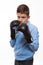 Emotional boy brunette in a blue shirt with boxing gloves in hands