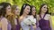 Emotional bride and bridesmaids talking and smiling. Caucasian girls in purple dresses posing outdoors.