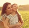 Emotional calm mother hugging her enjoying kid girl with closed