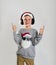 Emotional child boy with headphones pointing up on white background, space for text. Christmas music. Merry christmas