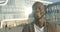 Emotional close-up portrait of the charming african man with beautiful white smile laughing over glass building